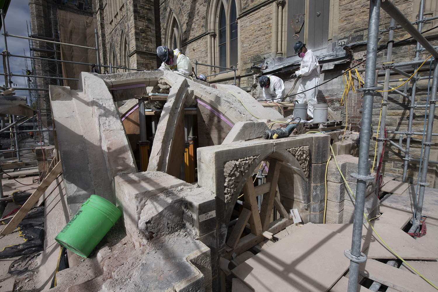 Des travailleurs démontent minutieusement le toit du porche du Sénat, pierre par pierre. (Crédit photo : Services publics et Approvisionnement Canada)