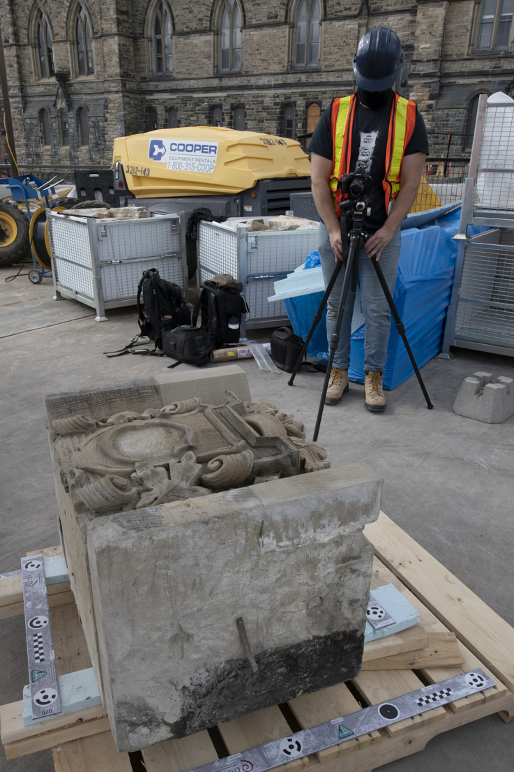 Un travailleur photographie une pierre retirée du porche du Sénat. (Crédit photo : Services publics et Approvisionnement Canada)