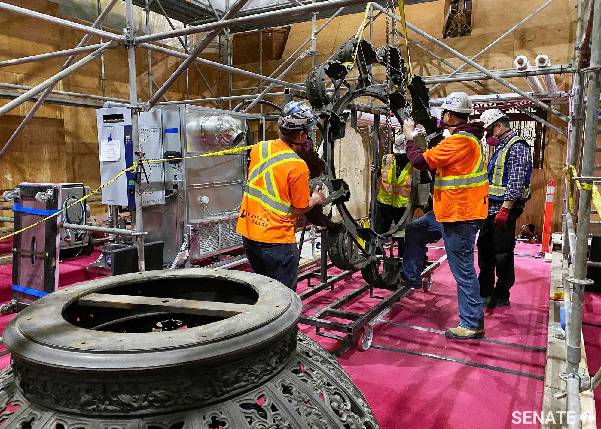 With the chandelier resting on a dolly, workers secure the giant ring to a custom-built frame on wheels. The ring, about 2.75 metres in diameter, was cast in one piece when it was forged — a feat “almost unheard of” for a lighting fixture, Mr. Nelson said. “That was one heck of a foundry at the Robert Mitchell Company, I can tell you.”