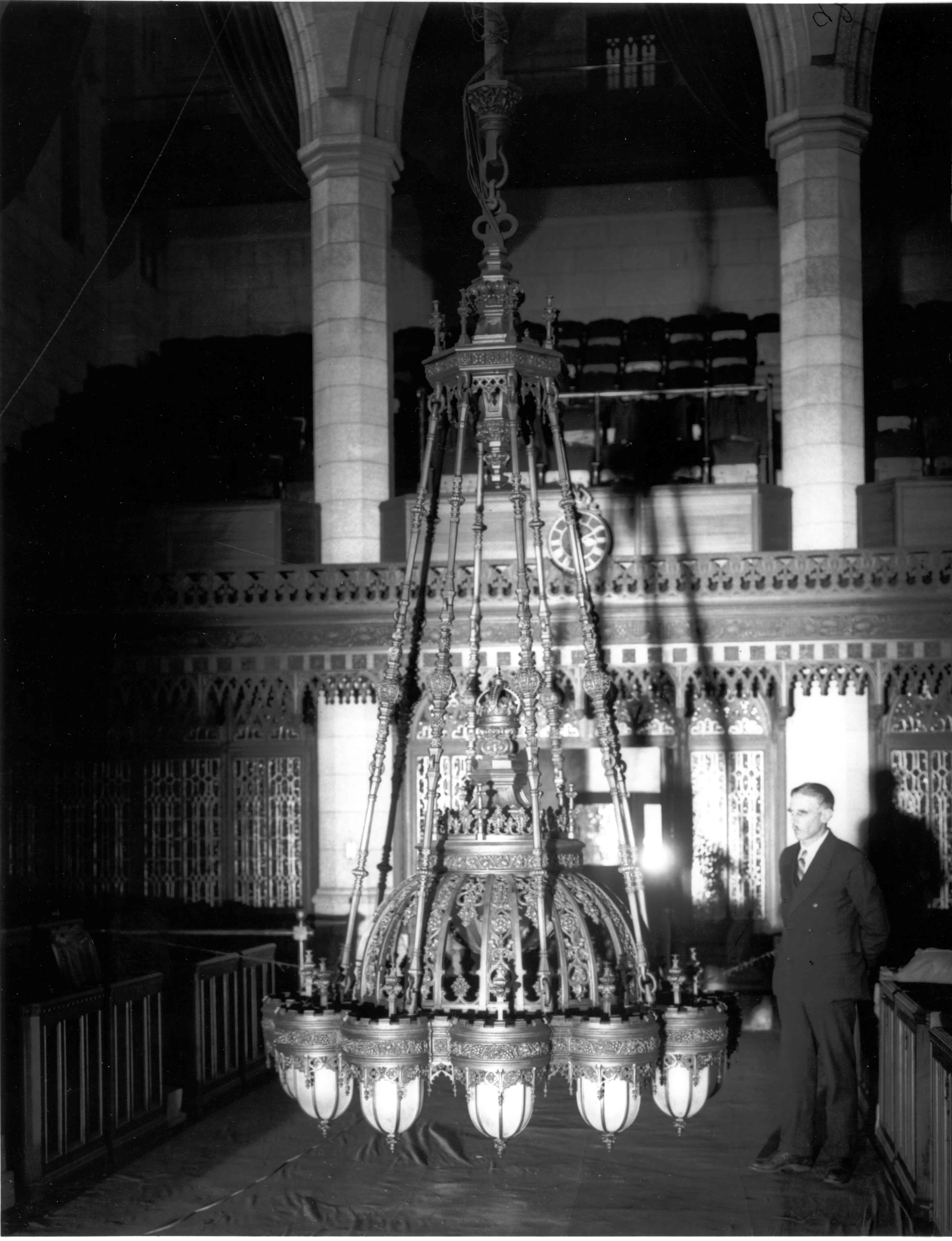 This undated photograph shows one of the Senate chandeliers, with its original egg-shaped lanterns, suspended close to the floor of the Red Chamber. Experts presume this image was taken prior to the lanterns’ replacement in the late 1950s. (Photo credit: Library and Archives Canada)