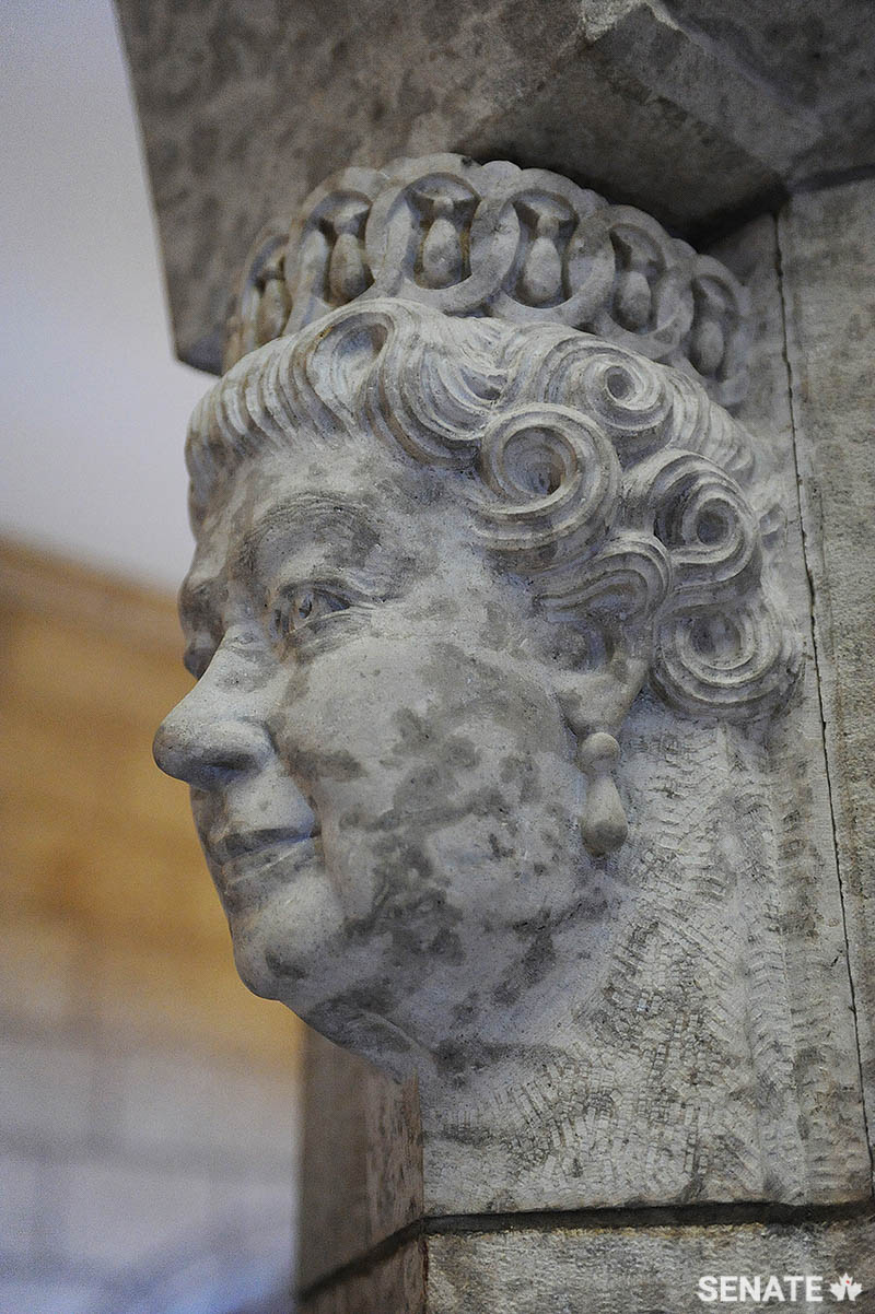 Phil White carved this portrait head of Queen Elizabeth II in Manitoba Tyndall stone, after the Queen approved a plaster preliminary model during her royal visit in 2010. The finished piece was installed in the Senate foyer later that year.