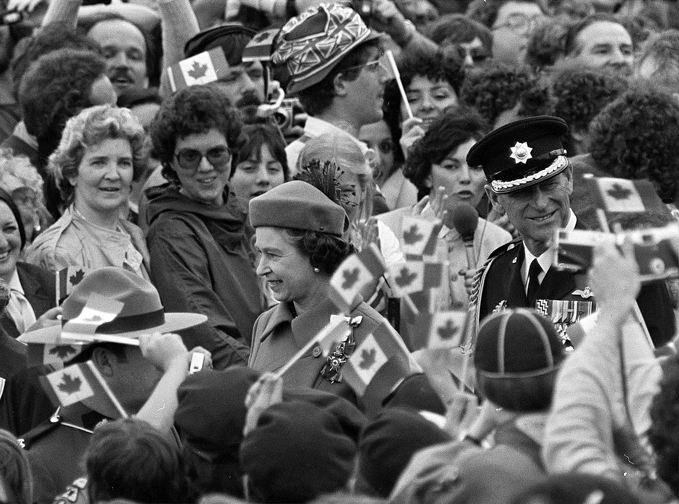 Queen Elizabeth and Prince Philip wave to crowds on Parliament Hill as they ride in an open carriage, escorted by RCMP officers, during the Queen’s Silver Jubilee visit to Canada in 1977. The Queen later opened the third session of the 30th Parliament with the reading of the Speech from the Throne from the Senate Chamber. (Photo credit: The Canadian Press)