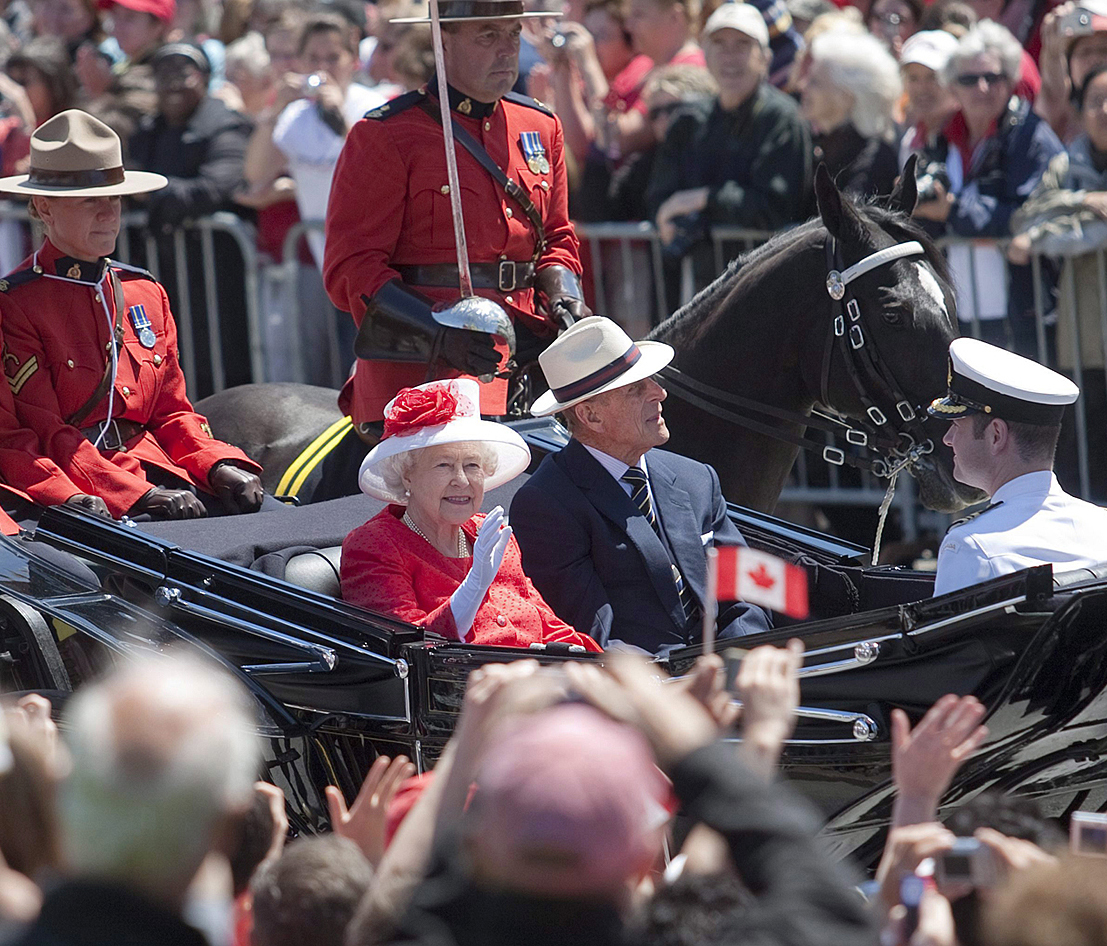Queen Elizabeth II and Prince Philip, Duke of Edinburgh, arrive by horse-drawn carriage for Canada Day celebrations on Parliament Hill in 2010 as part of the royal couple’s 21st tour of Canada. The visit marked Prince Philip’s 45th to the country. (Photo credit: The Canadian Press)