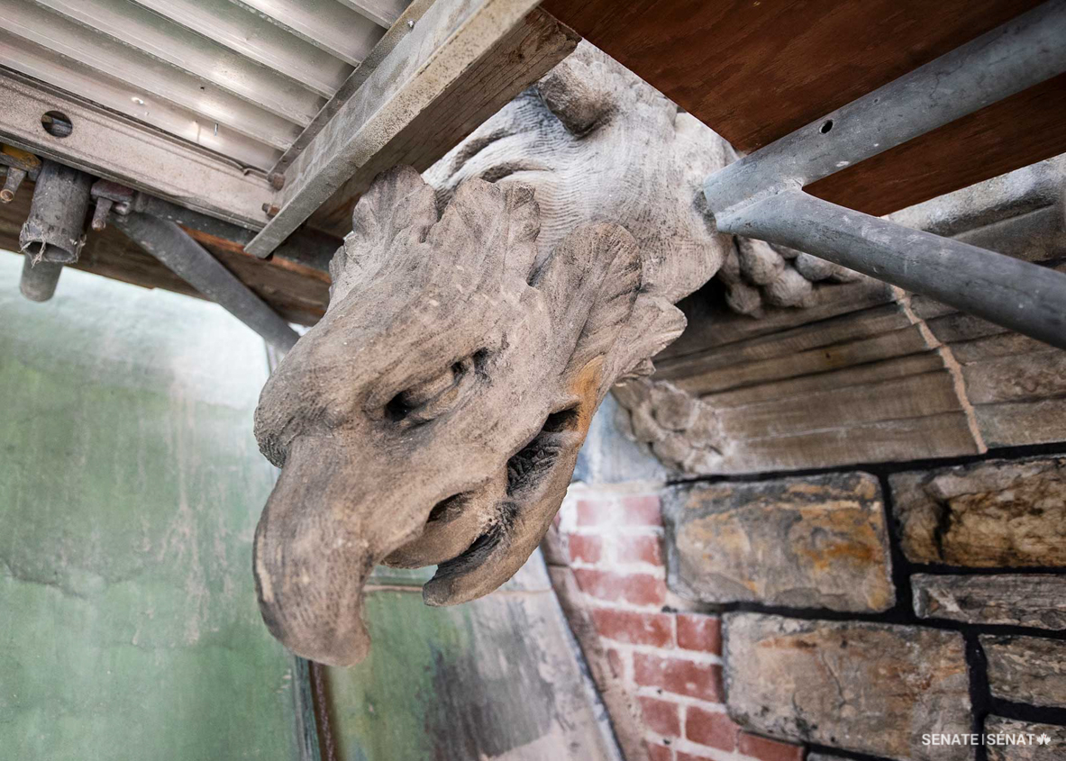 Scaffolding erected against East Block’s exterior facilitates the rehabilitation work but is installed carefully to prevent damage to the building’s special stone features, like this grotesque. Workers receive training on East Block’s heritage value and are instructed to protect heritage elements and leave them exposed only when they need to be accessed.
