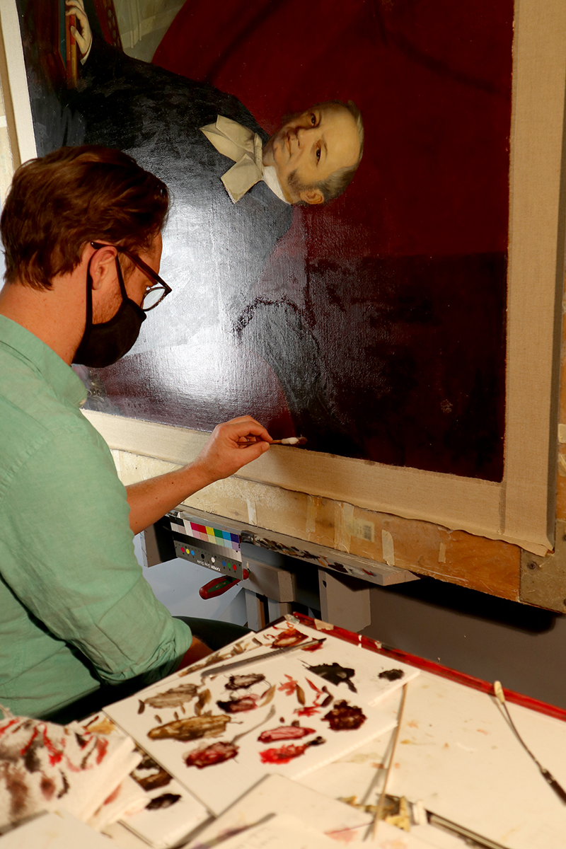 Conservator David Legris removes varnish on the portrait of former Senate Speaker Pierre-Joseph-Olivier Chauveau. (Photo credit: Legris Conservation)