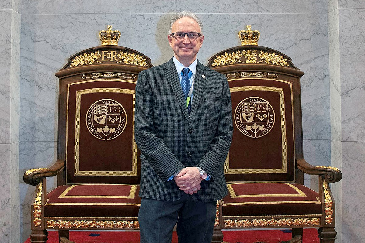Mr. White poses with the royal thrones he designed for the temporary Senate Chamber in the Senate of Canada Building. Beaux Arts details in the thrones were inspired by the building itself, a former railway station built in 1912. (Photo credit: Public Services and Procurement Canada)
