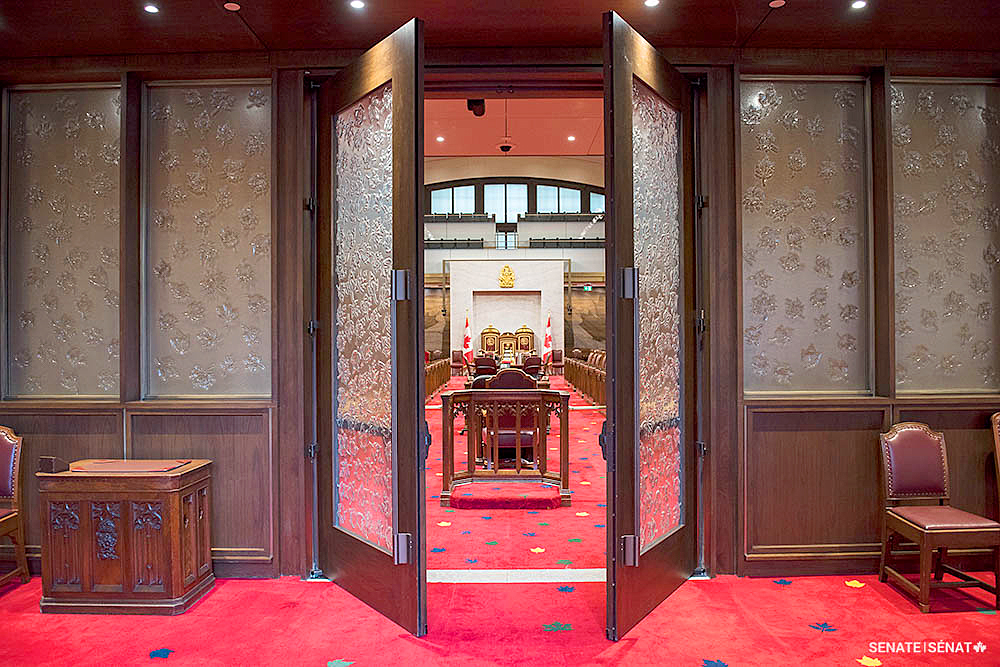 M. White a conçu de nombreux éléments de la Chambre temporaire du Sénat, y compris les feuilles d’érable qui ornent les panneaux de verre des portes, les armoiries des provinces et des territoires, les armoiries du Canada, les trônes royaux et le fauteuil du Président.