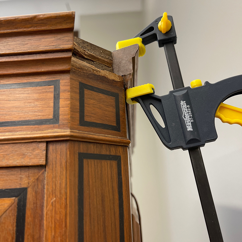 Sections of the walnut-wood trim needed repairs, including this piece of crown moulding. (Photo credit: Alexander Gabov)