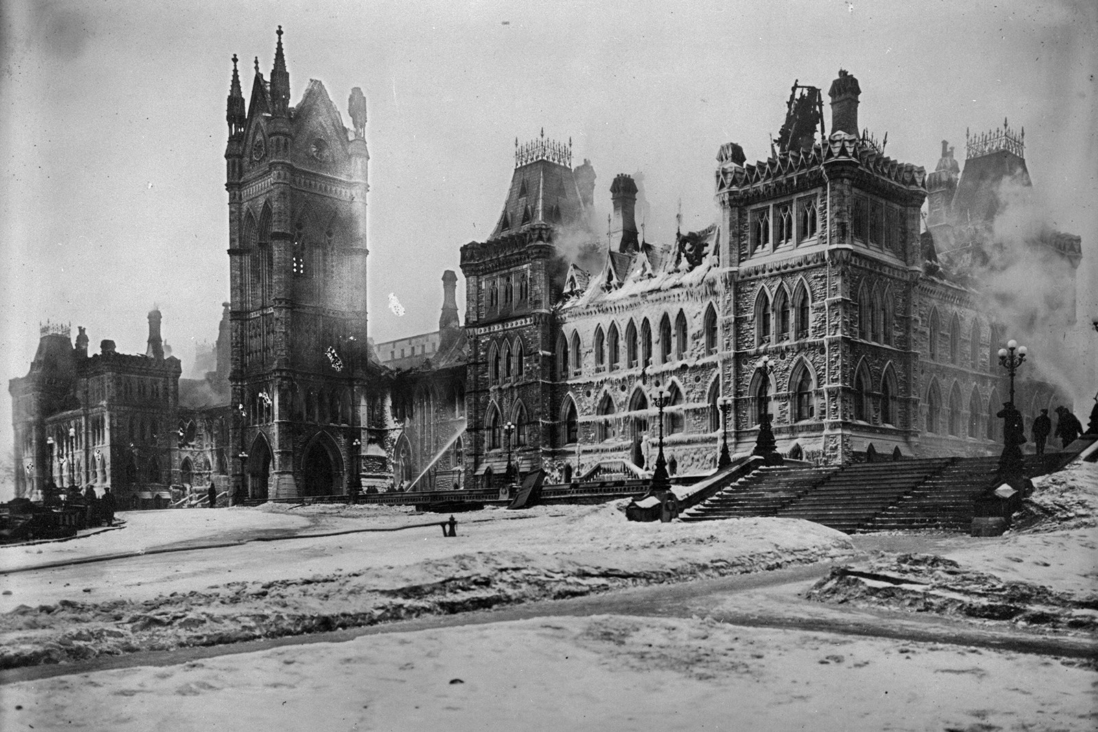 Les pompiers passent la nuit du 3 au 4 février 1916 à arroser l’édifice du Centre. Le lendemain, il ne reste rien d’autre qu’une coquille recouverte de glace. (Crédit photo : Bibliothèque et Archives Canada)