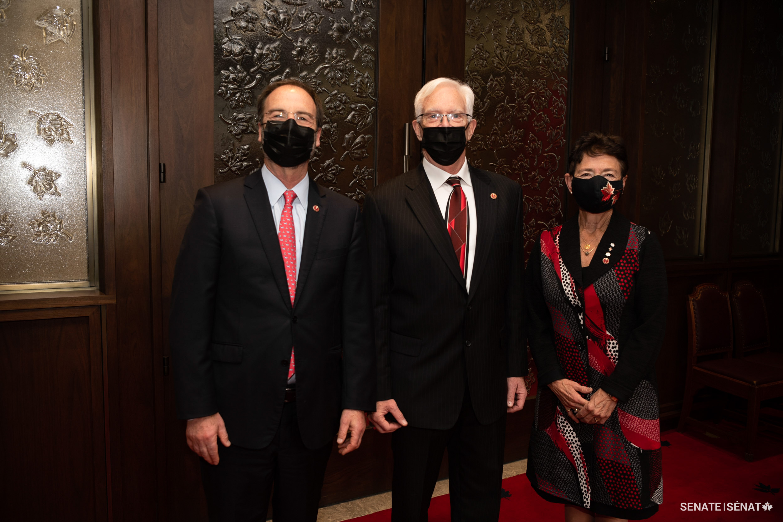 Senator David M. Arnot, centre, stands with senators Marc Gold and Bev Busson after his swearing-in ceremony.