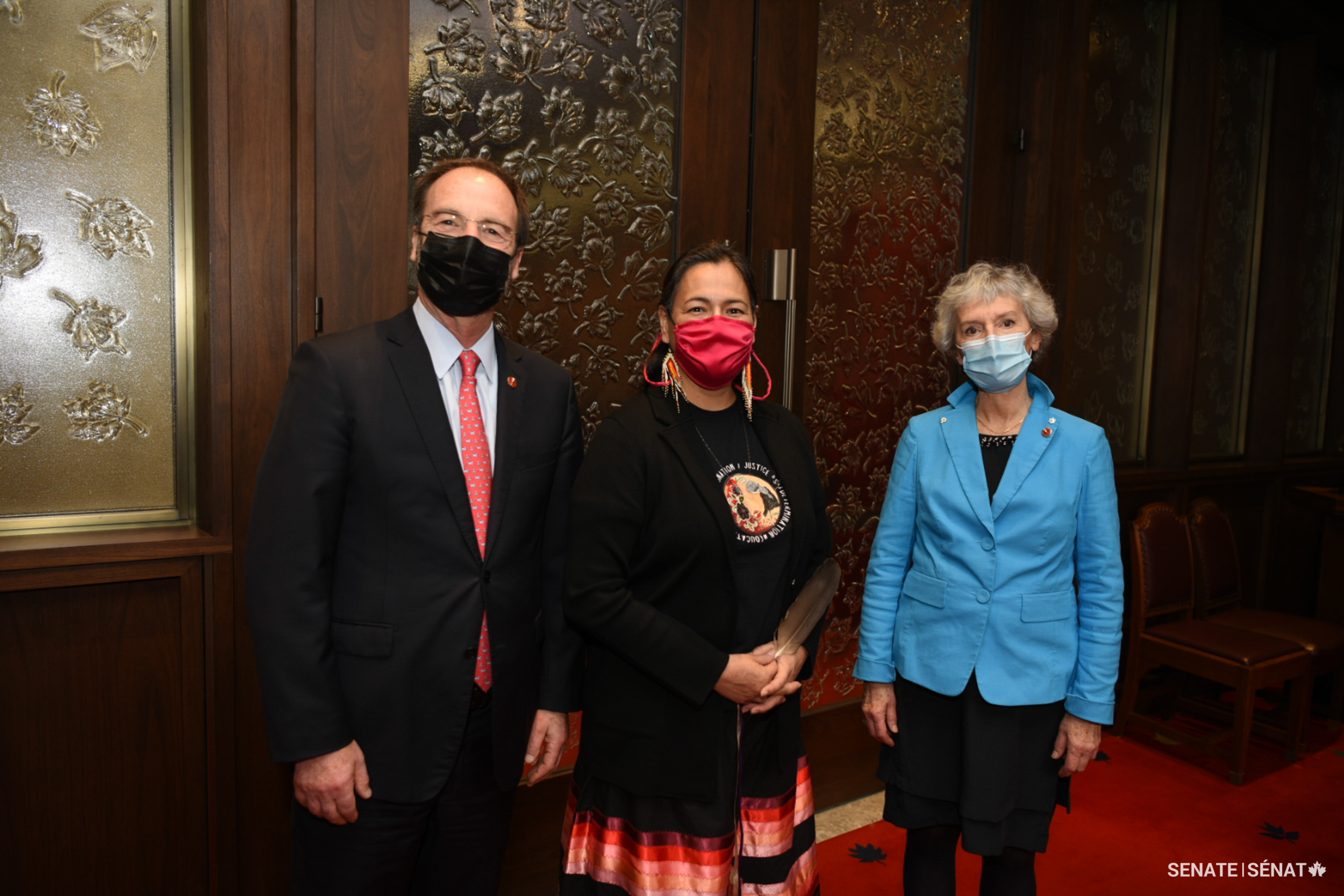 Senator Michèle Audette, centre, stands with senators Marc Gold and Renée Dupuis after her swearing-in ceremony.