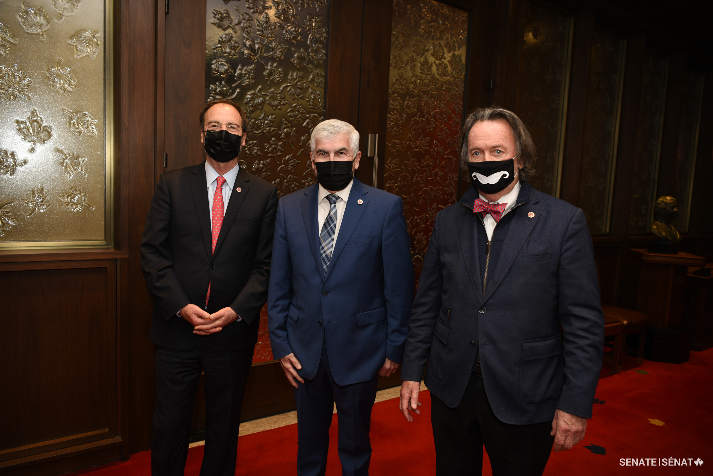Senator Clément Gignac, centre, stands with senators Marc Gold and Dennis Dawson after his swearing-in ceremony.