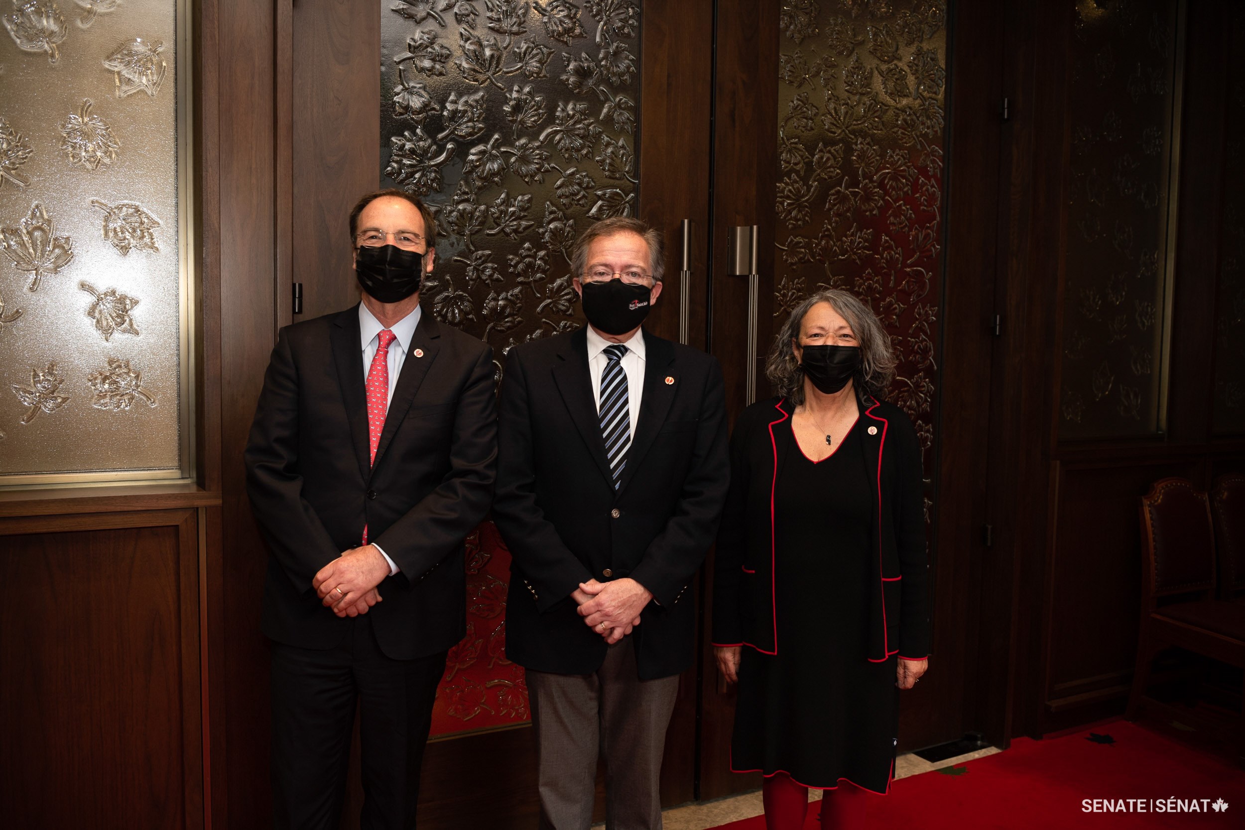 Senator Jim Quinn, centre, stands with senators Marc Gold and Pierrette Ringuette after his swearing-in ceremony.
