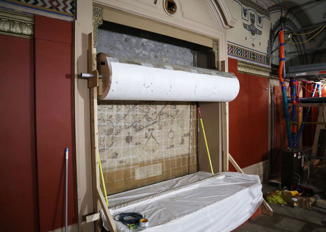 The mural of the map is rolled onto a custom support during the removal process. (Photo credit: Legris Conservation Inc.)