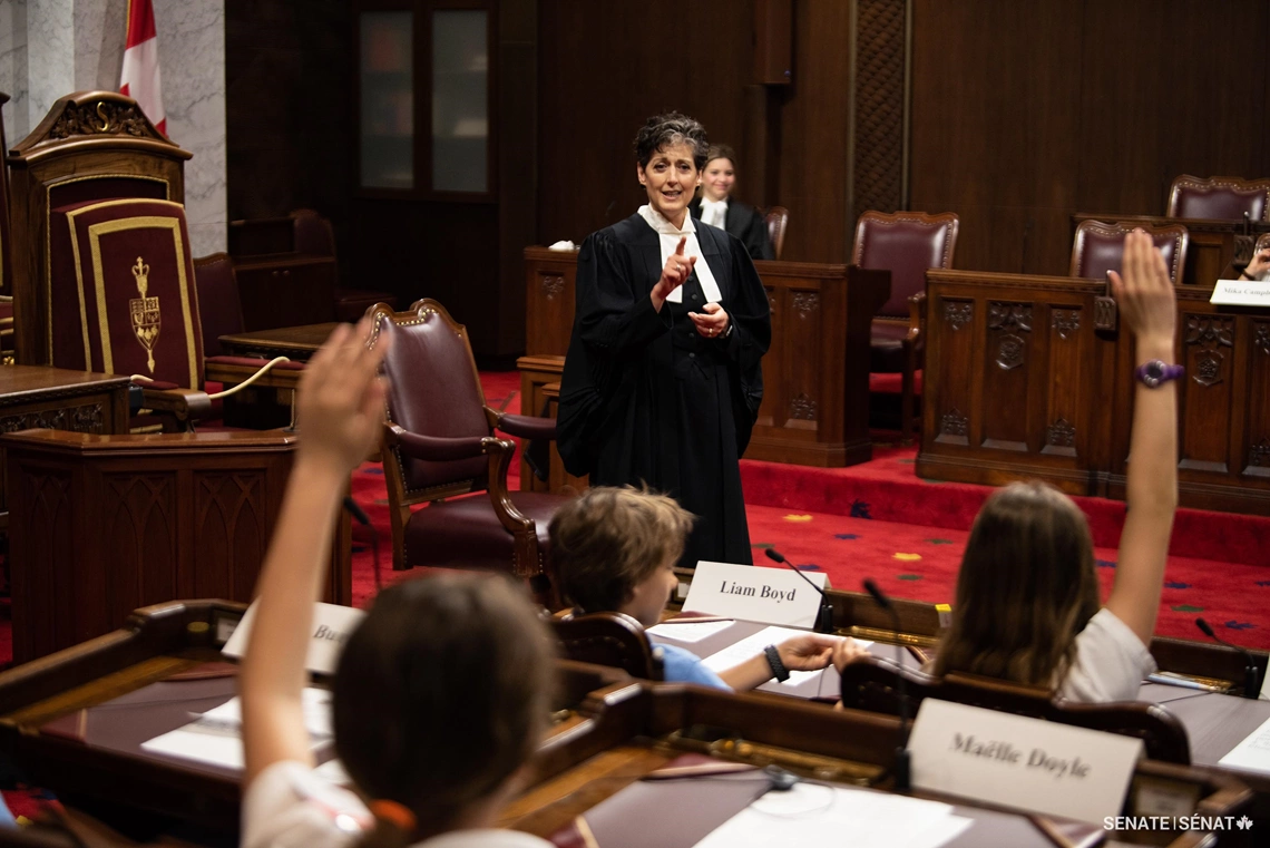 Senator Forest-Niesing — in her lawyer’s robes — meets with Grade 6 students on the Senate Chamber on May 17, 2019.