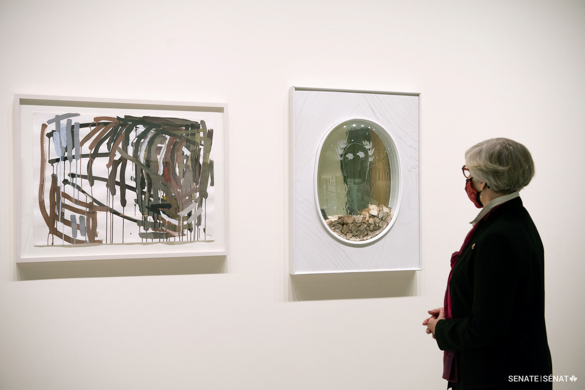 Senator Patricia Bovey admires Wyoming Saddle (2000) by Denyse Thomasos, left, and Light Laureate (2019-2020) by Tim Whiten, which she arranged to have exhibited in the foyer of the Senate of Canada Building.