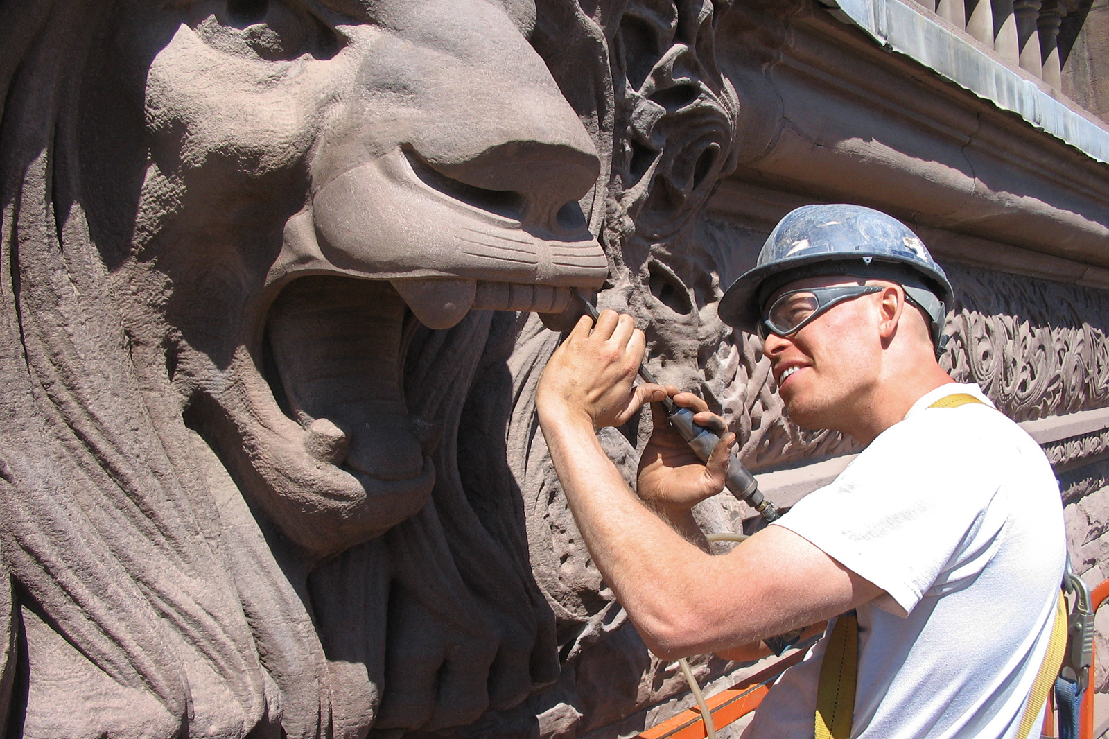 M. Smith répare un lion décoratif sur la façade de l’édifice de l’Assemblée législative de l’Ontario, à Queen’s Park, à Toronto. (Crédit photo : John-Philippe Smith)