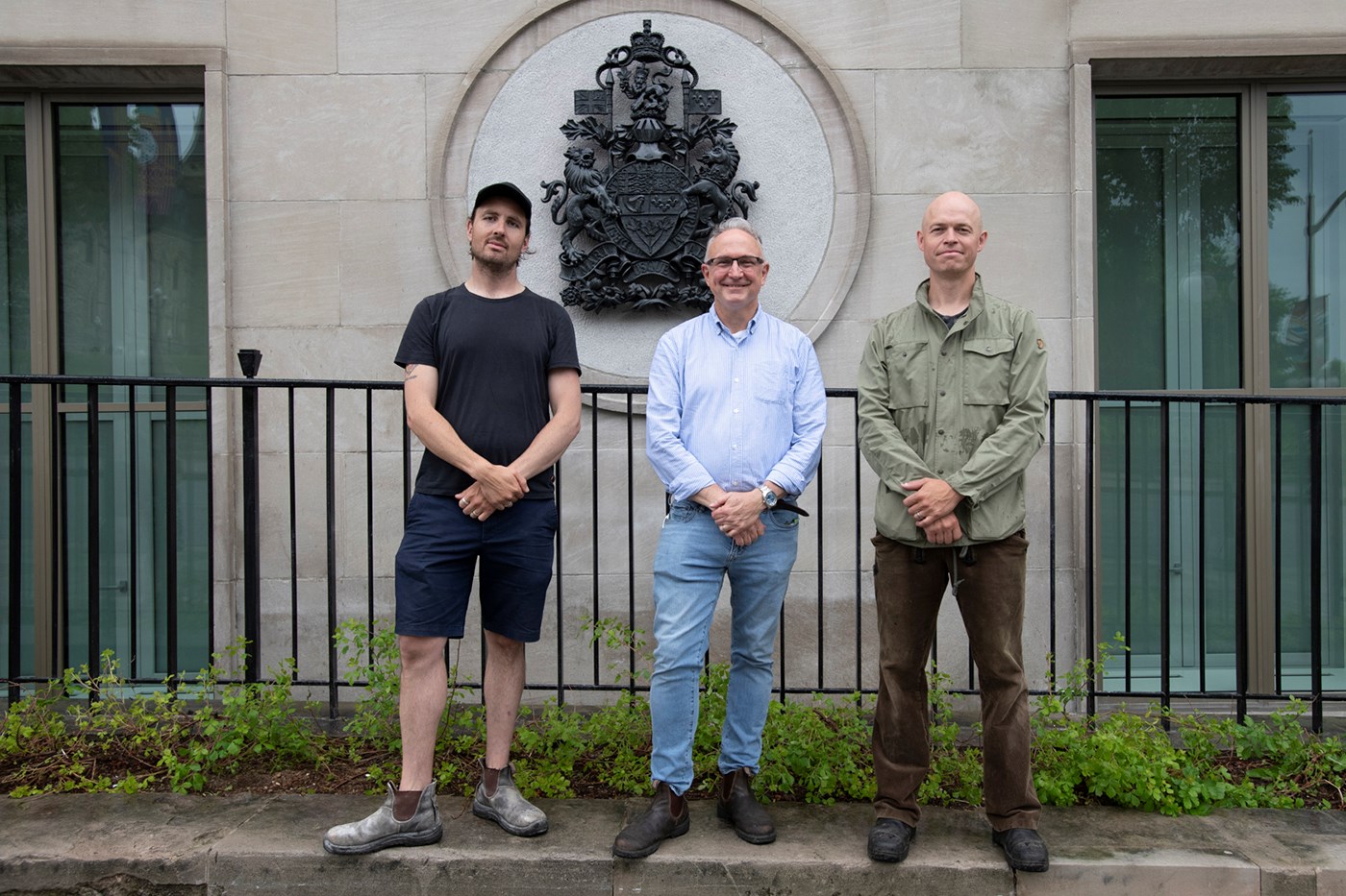 The parliamentary sculpting team in 2019 — from left, Nicholas Thompson, Phil White and John-Philippe Smith — stand in front of a sculpture of the Arms of Canada they created. The sculpture was cast in bronze and mounted on the north face of Ottawa’s Wellington Building. (Photo credit: Public Services and Procurement Canada)