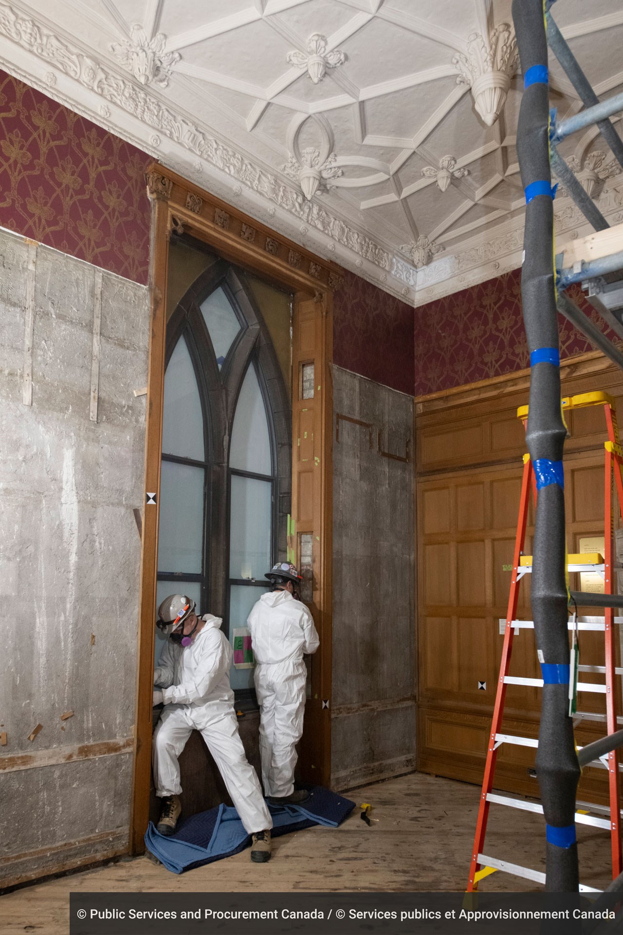 Carpenters remove wood panels from a window surround in the Senate Reading Room.