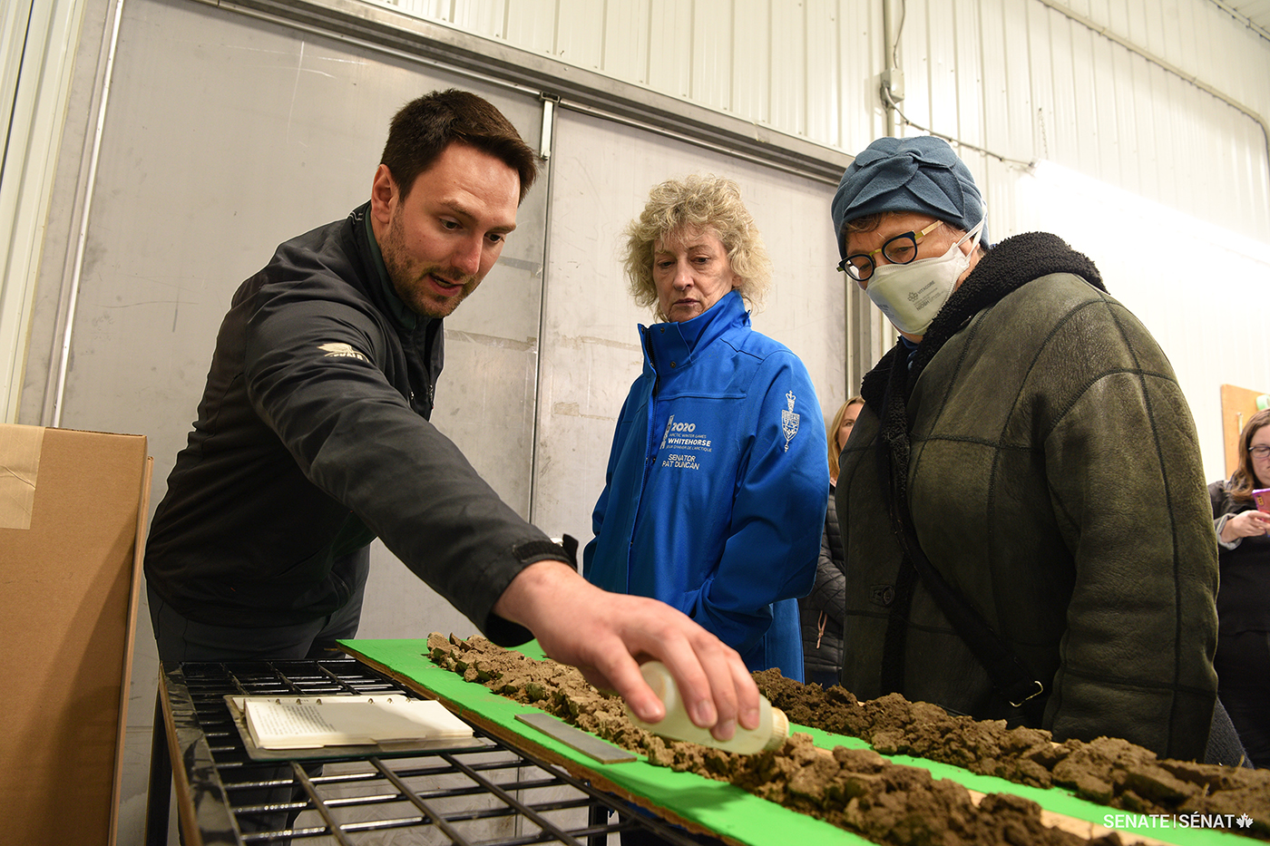 Woodrill Ltd. agronomist Caleb Niemeyer shows senators Duncan and Simons how hydrochloric acid reacts to different types of soil. Woodrill is a crop input supply company and grain elevator business.