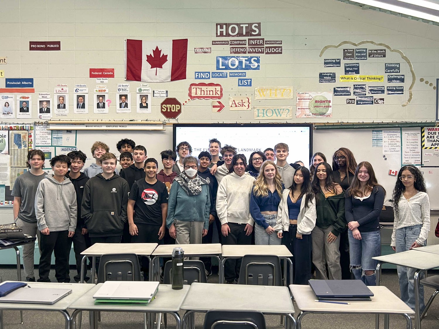 Un groupe de personnes est photographié dans une salle de classe