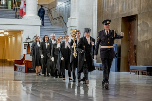 The procession of the Speaker’s Parade including the Speaker of the Senate, the Usher of the Black Rod, the Mace Bearer and other Senate officials through the hallways of the Senate of Canada Building