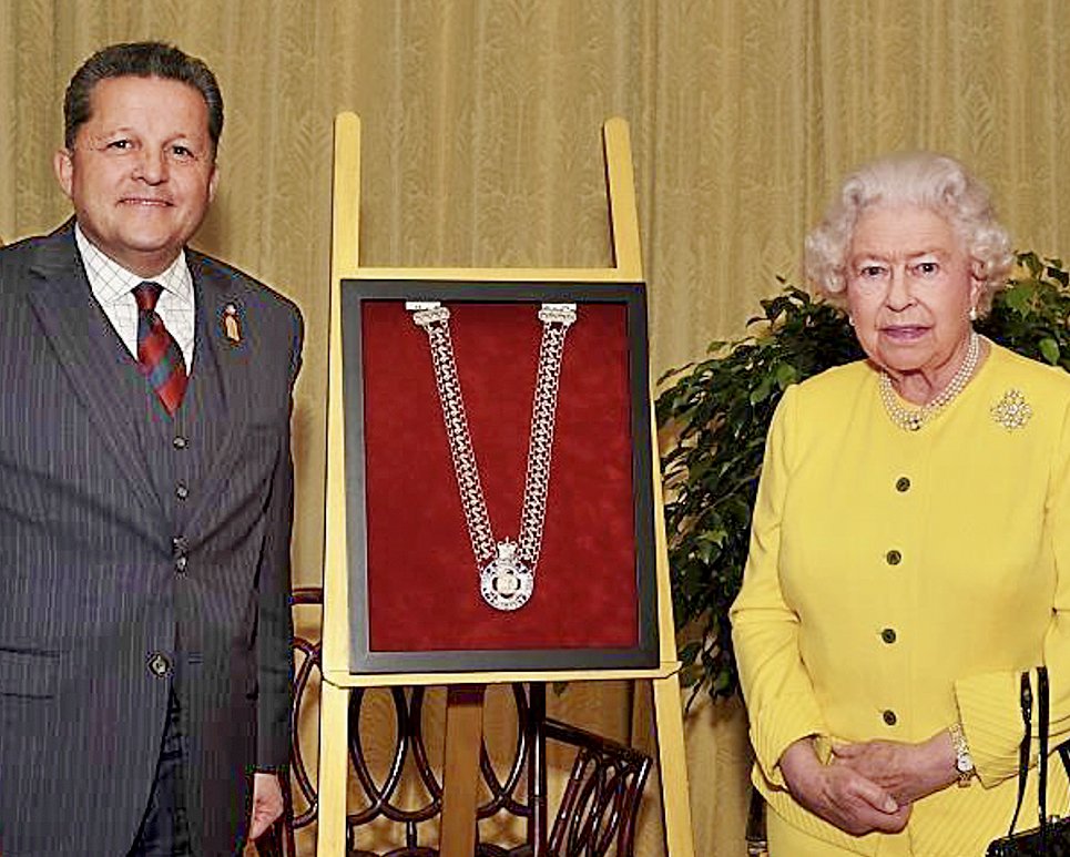 Queen Elizabeth II and Mr. Peters stand with the newly created chain of office during a ceremony at Windsor Castle in 2014.