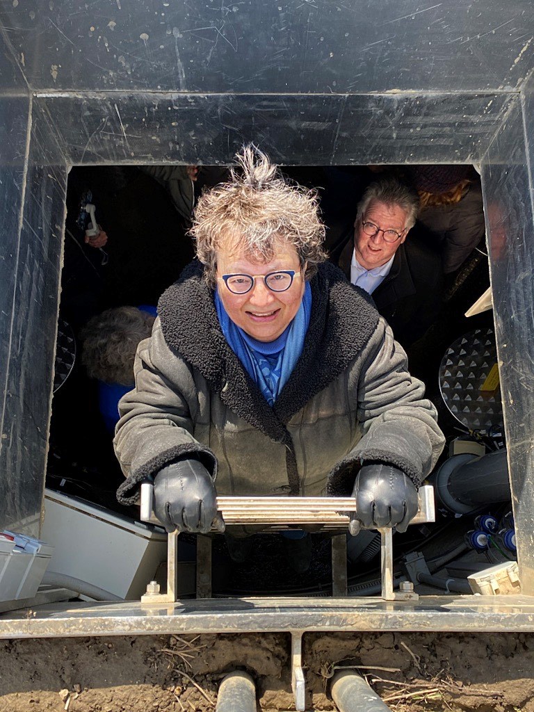 La sénatrice Simons sort d’un puits de lysimètre de la Station de recherche Elora de l’Université de Guelph sous le regard du sénateur Black. Les puits de lysimètre mesurent la teneur en humidité du sol. (Crédit photo : Bureau de la sénatrice Paula Simons)