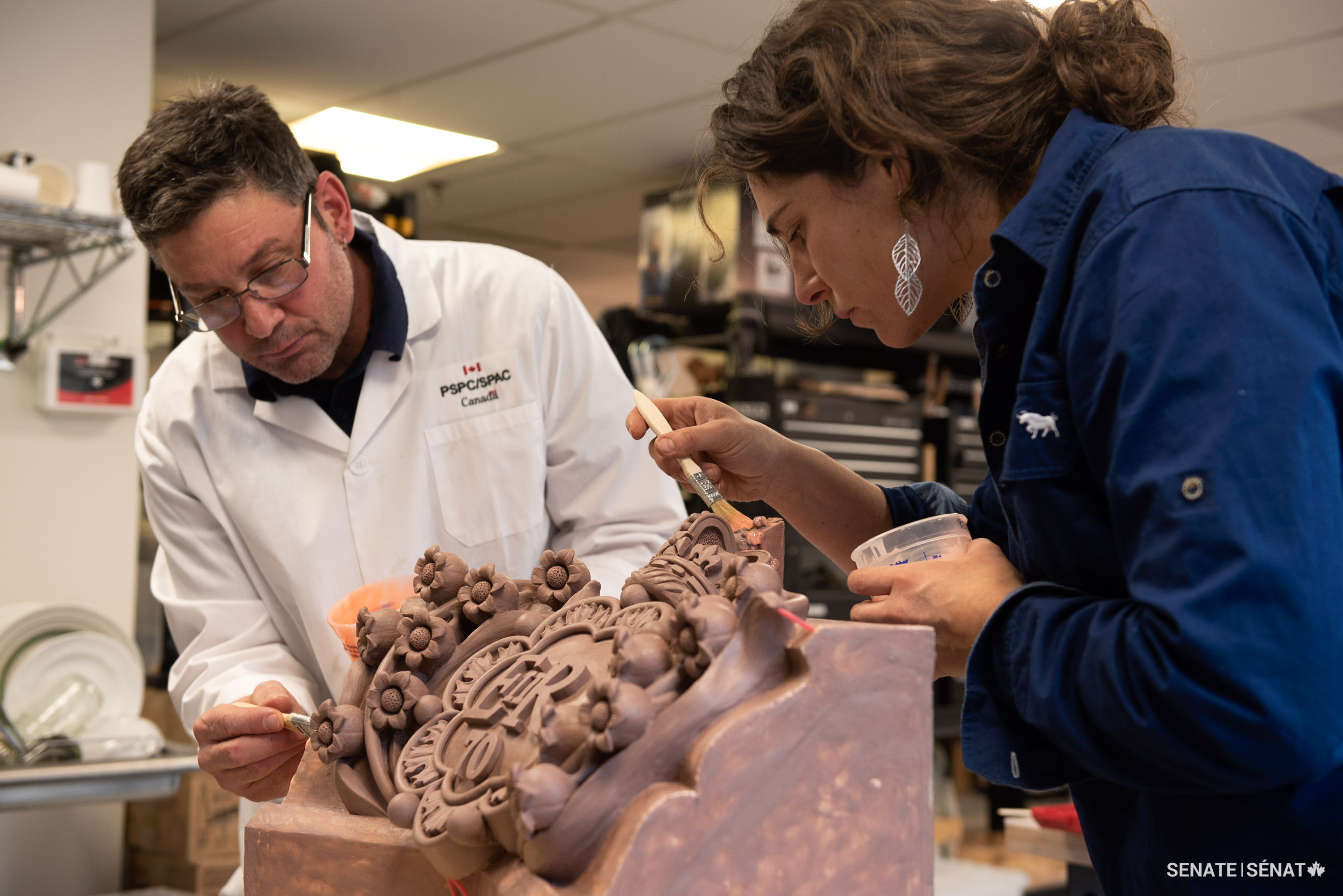 Sculptors Danny Barber and Anna Williams begin to prepare the mould, brushing liquid silicone over the clay model.
