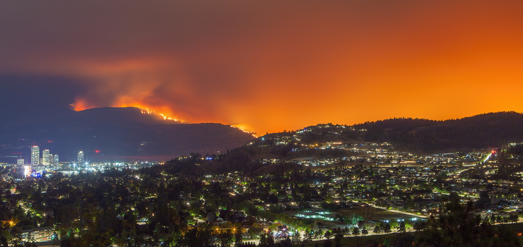 Un feu de forêt fait rage sur le flanc d’une montagne, près d’une ville.