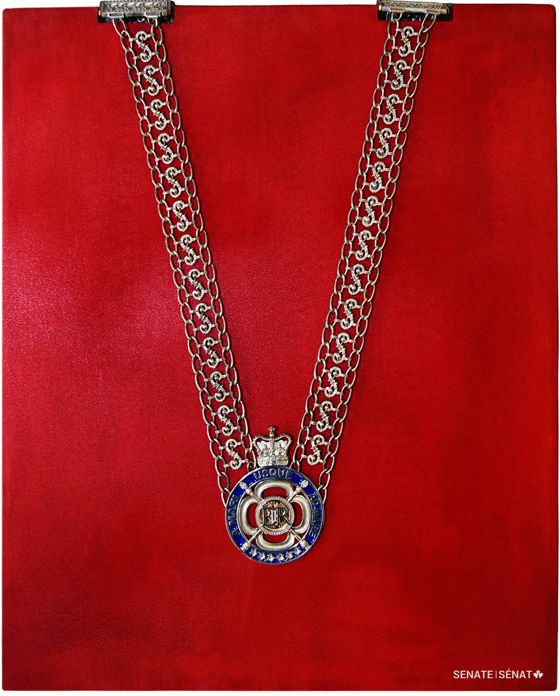 The centrepiece of the chain of office is a silver-and-blue medallion. It is suspended from two chains forming a series of S-shaped links that represent the Senate.