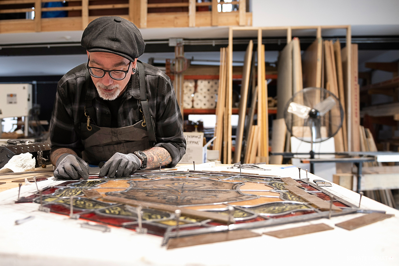 Conservator John Martin re-leads a window, joining pieces of glass together with strips of lead called came. The lead must be cut exactly — the tiniest gap can allow molten lead solder to seep through and crack the glass.