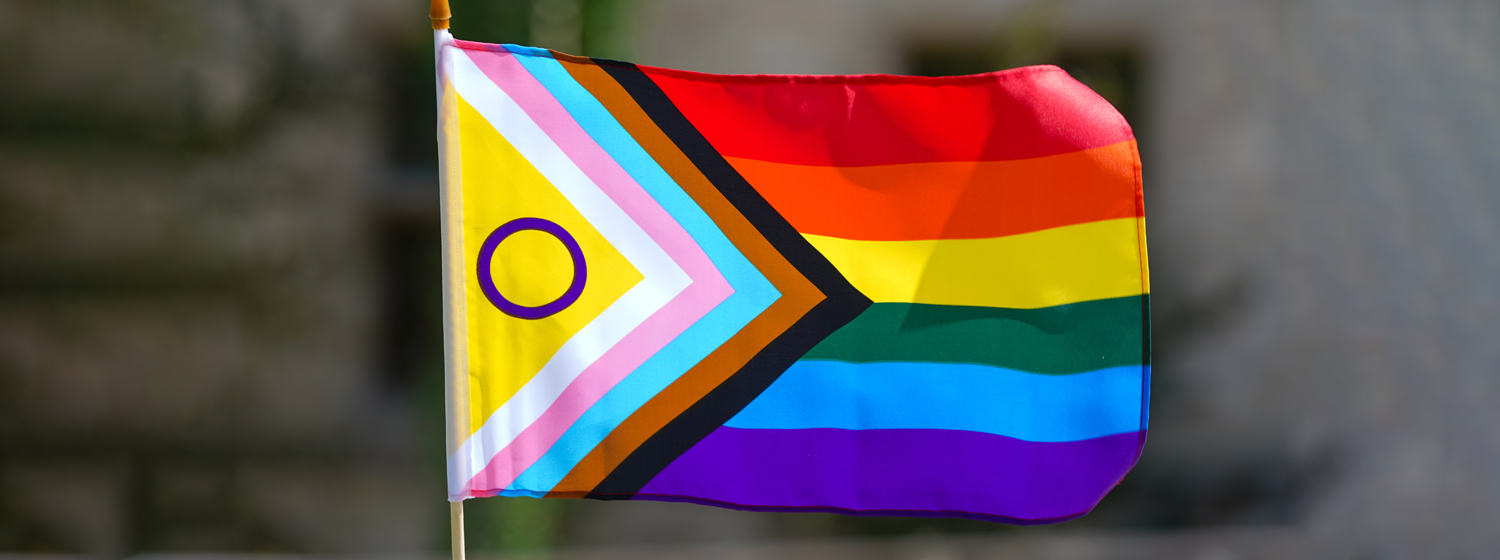 A Pride flag waves in the wind.