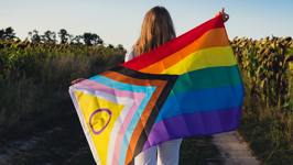 A person holds a Pride flag.