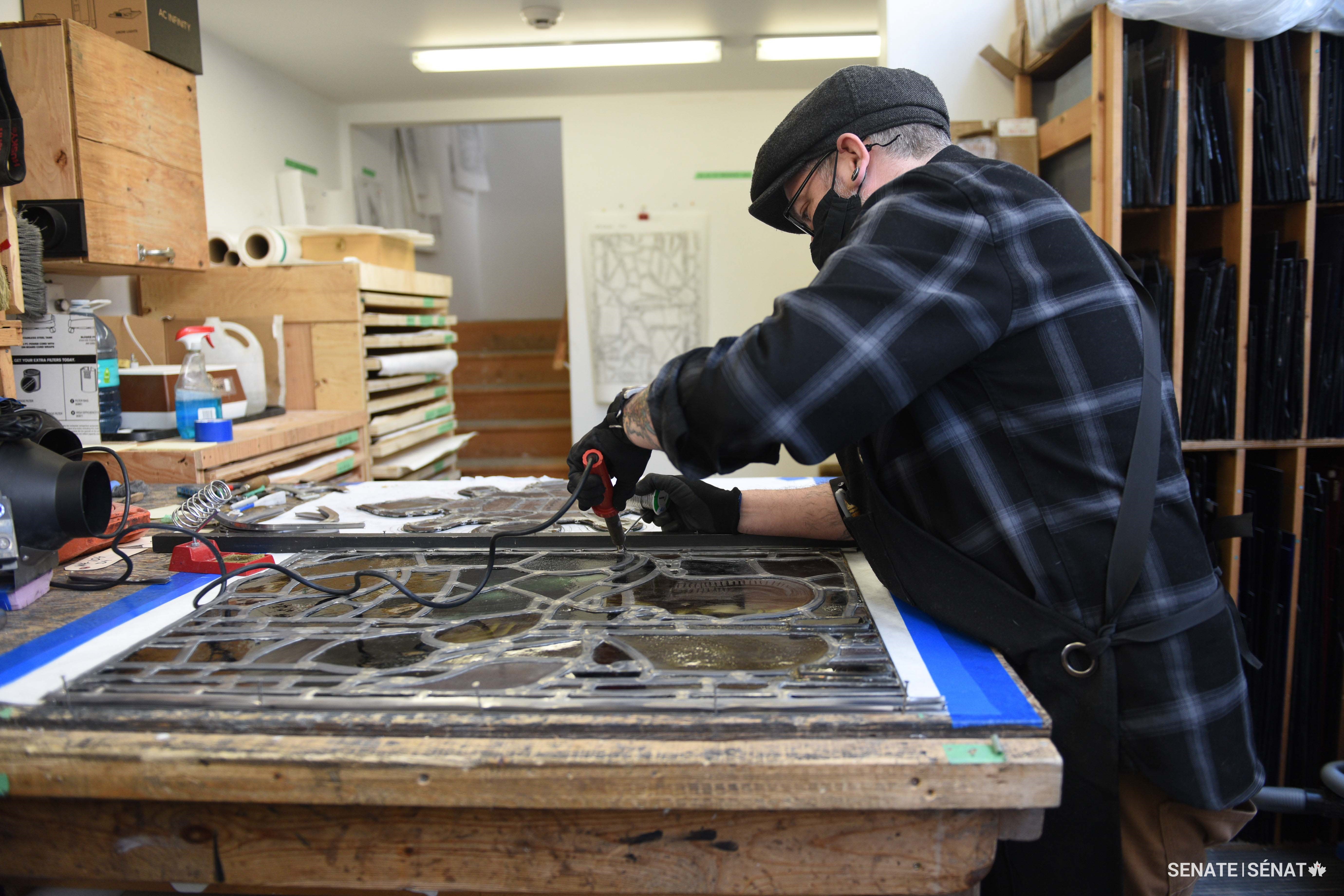 Senior conservator John Martin solders a new edge lead to replace lead that had become corroded by the mortar used to help hold the window in place.