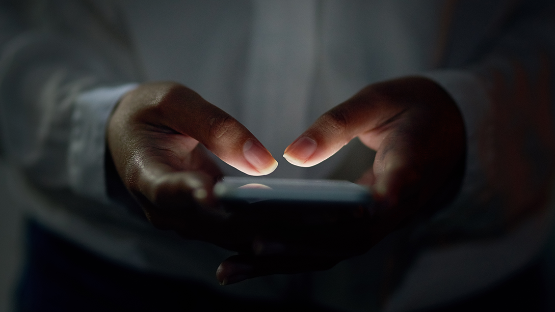 A close-up of hands holding a smartphone.