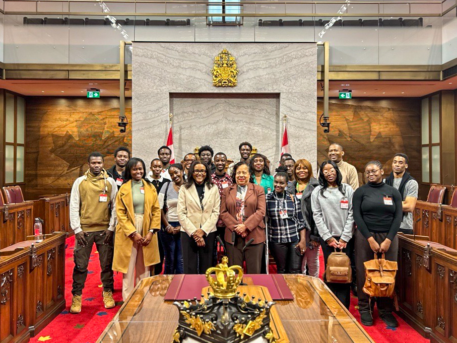 Thursday, February 27, 2025 – Senators Marie-Françoise Mégie and Suze Youance, centre, with members of the Mosaïque Interculturelle; tour of the Senate Chamber; coordinated by SENgage; Senate of Canada Building, Ottawa, Ontario.
