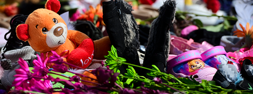 Un mémorial de jouets, de chaussures pour enfants et de fleurs.