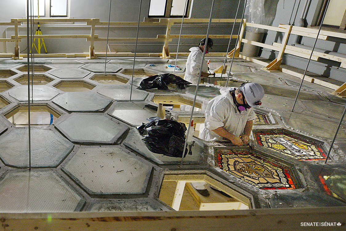 Technicians from Traditional Glassworks remove panels on the Senate foyer ceiling. Scaffolds gave conservators access to the lightwell above the drop ceiling, allowing them to work without applying weight to the fragile concrete lattice.