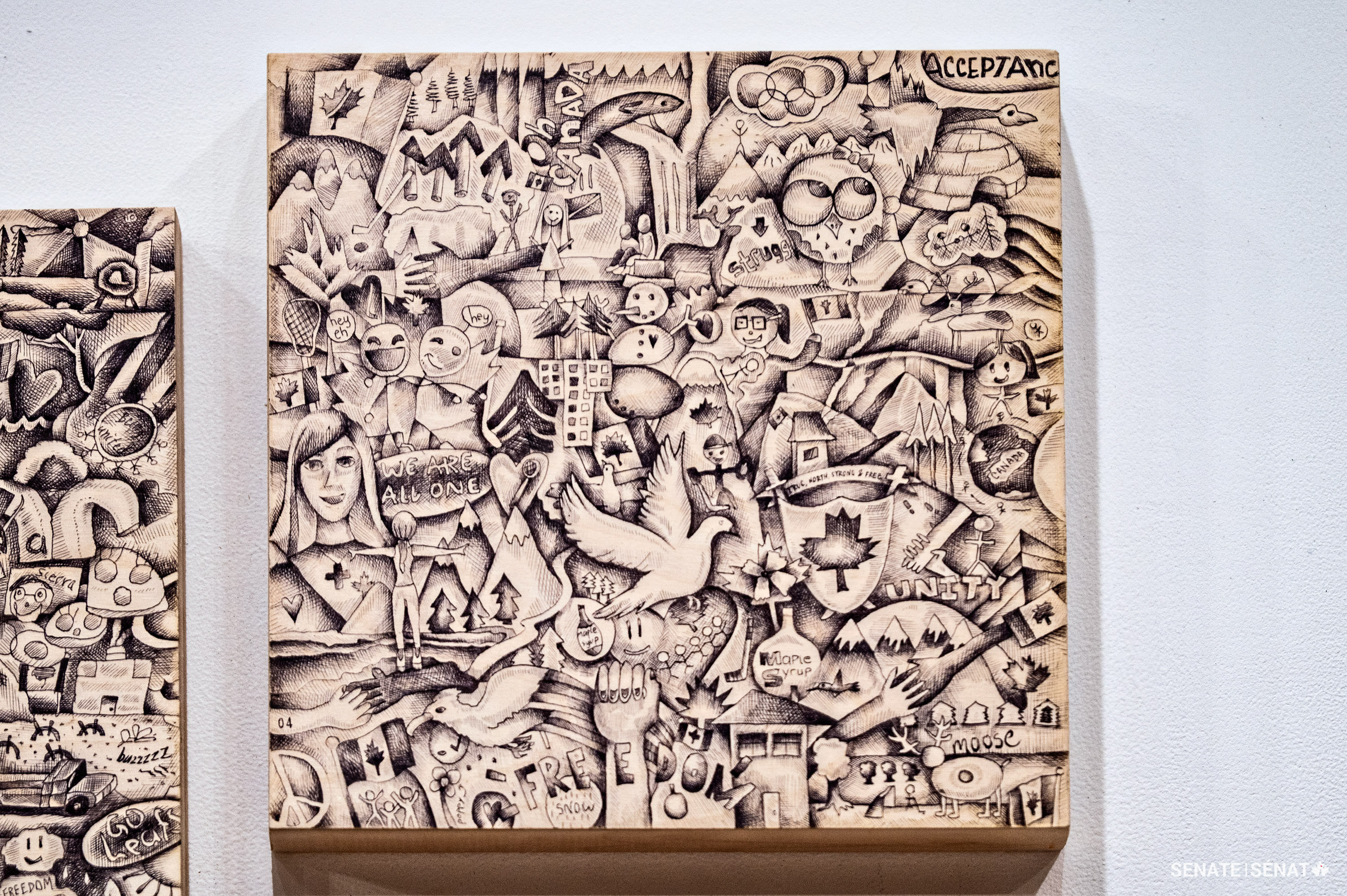 Aquil Virani en collaboration avec Rebecca Jones, détail de L’autoportrait du Canada (2016). 18 panneaux de bouleau et encre. 86,4 cm x 165,1 cm. Provenance du prêt : avec l’autorisation de l’artiste. L’œuvre intègre 800 croquis participatifs illustrant l’identité canadienne. 