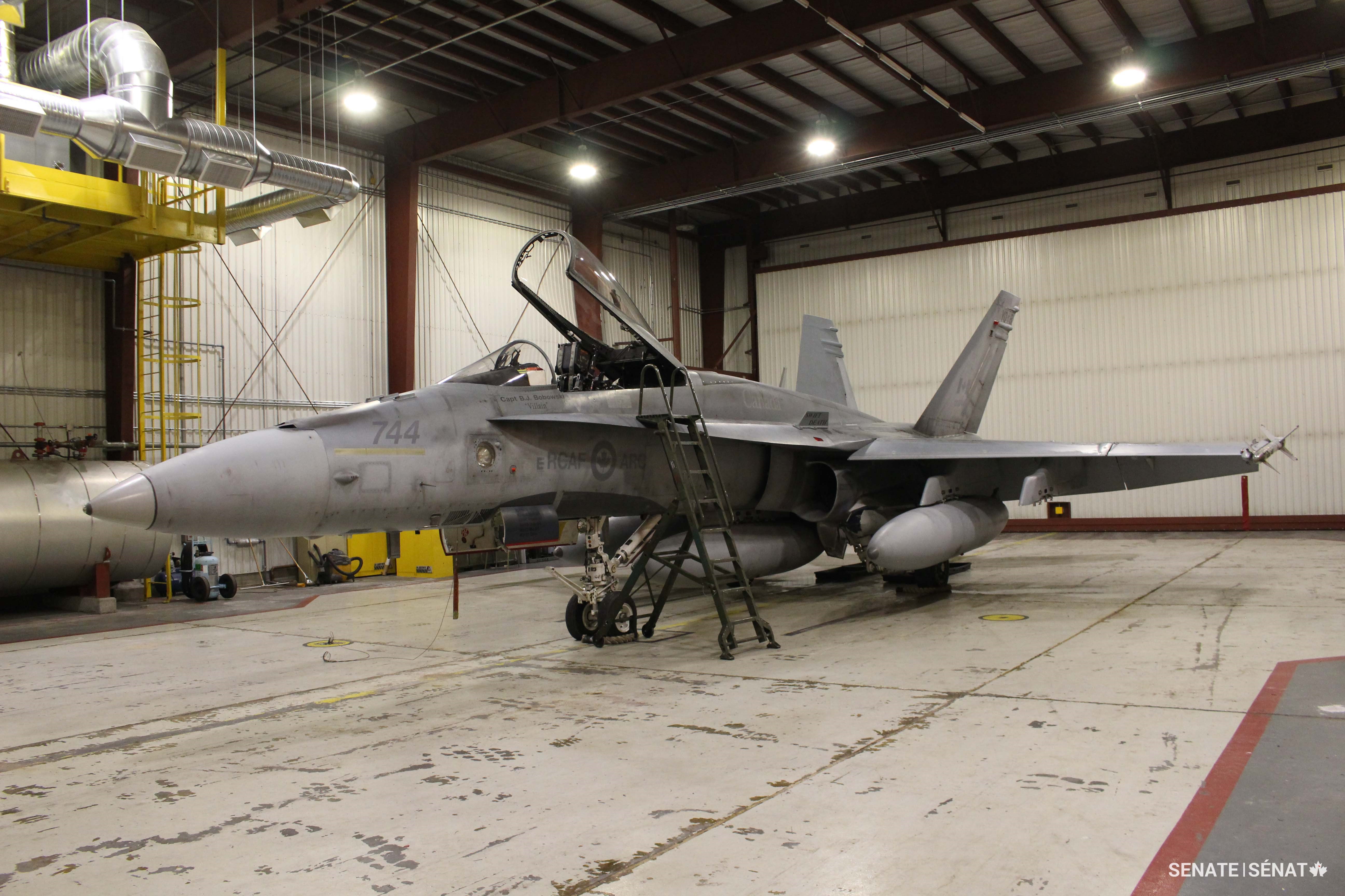 A CF-18 sits in a hangar at the Inuvik airport, which doubles as a NORAD forward operating location. CF-18s must use specially installed aircraft-carrier arresting gear to land because the runway is too short.