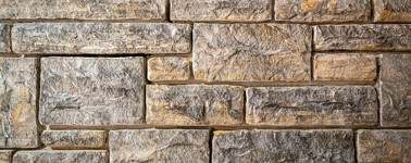 A closeup of a roughly textured sandstone wall.
