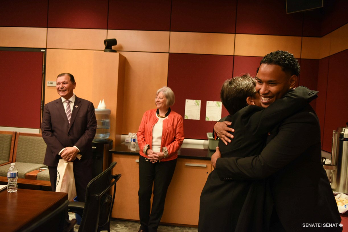 Mr. Maxie of White Bear First Nation in Saskatchewan, right, hugs Senator Kim Pate during the Voices of Youth Indigenous Leaders event at the Senate of Canada Building. Also pictured are Senator Brian Francis, chair of the Senate Committee on Indigenous Peoples, left, and Senator Nancy J. Hartling.