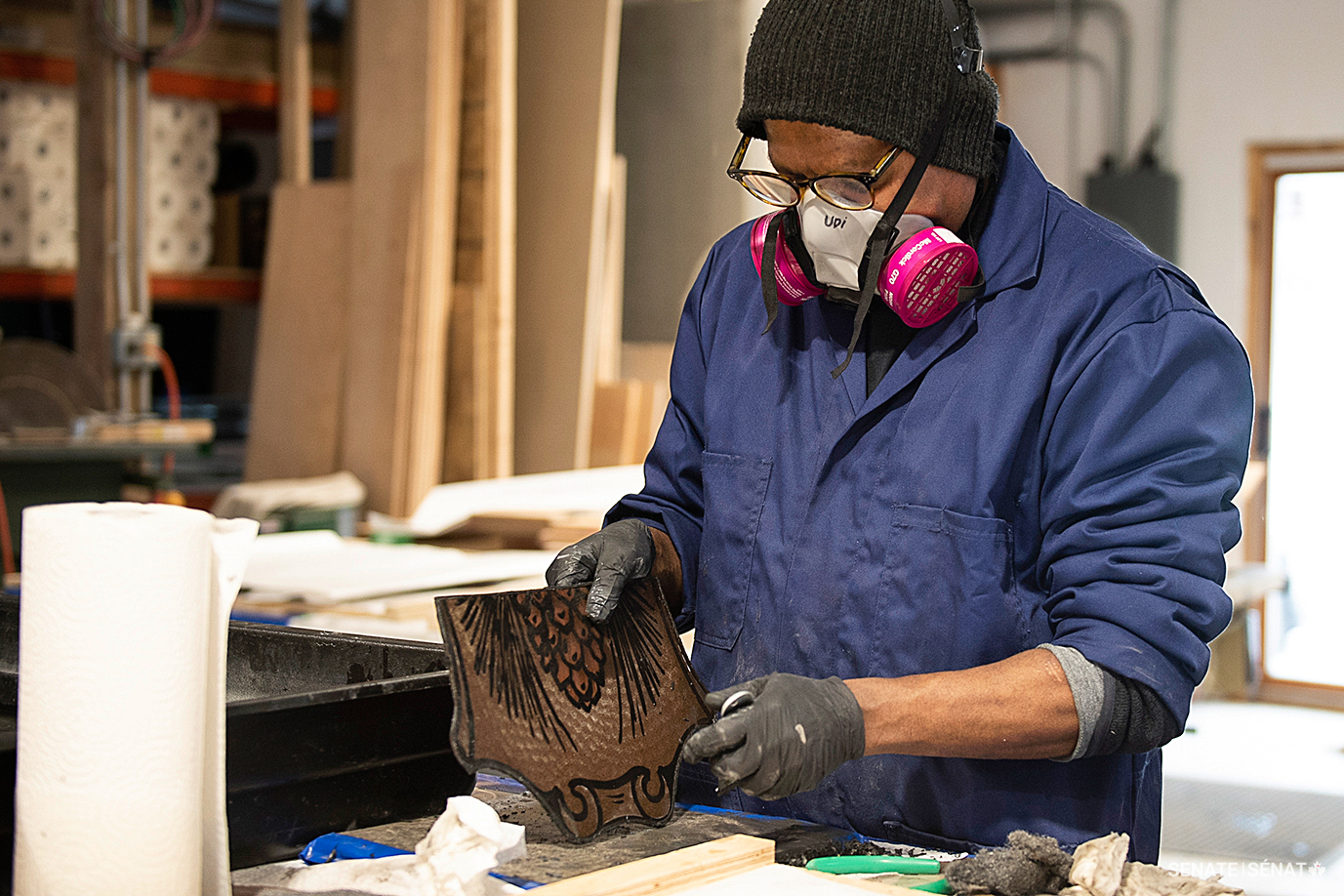 Conservator Udiya Swamy cleans the edges of a newly disassembled piece of glass.