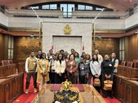 Un groupe de personnes posent pour une photo dans la Chambre du Sénat.