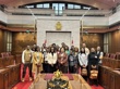 A group of people pose for a photo in the Senate Chamber. 