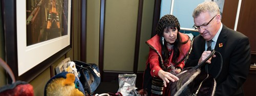 Senator Fabian Manning and Métis artist Cheryl Fennell examine a sealskin bag at an event celebrating seal products.