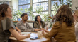 Quatre femmes et un homme assis autour d’une table dans un bureau.