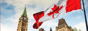 Un drapeau du Canada flotte au vent à l’extérieur de la Colline du Parlement à Ottawa.
