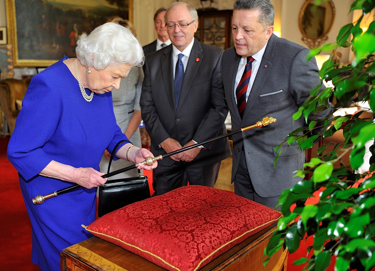 Queen Elizabeth inspects the Black Rod after its 2016 restoration as Senate Speaker George J. Furey (centre) and Usher of the Black Rod J. Greg Peters (right) look on. (Photo credit: Office of the Usher of the Black Rod)